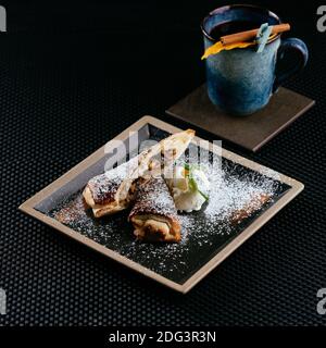 Verschiedene Desserts mit Tee auf schwarzem Hintergrund Stockfoto