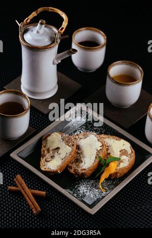 Verschiedene Desserts mit Tee auf schwarzem Hintergrund Stockfoto
