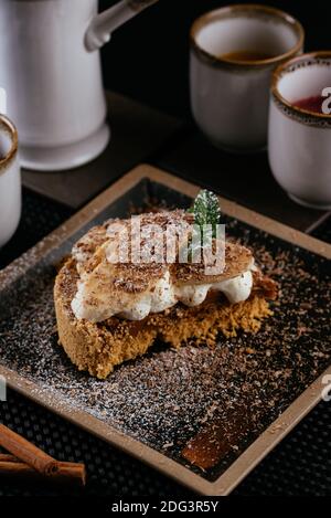 Verschiedene Desserts mit Tee auf schwarzem Hintergrund Stockfoto