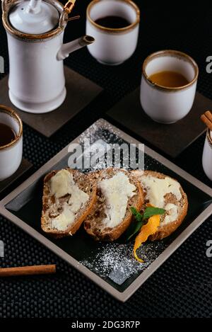 Verschiedene Desserts mit Tee auf schwarzem Hintergrund Stockfoto