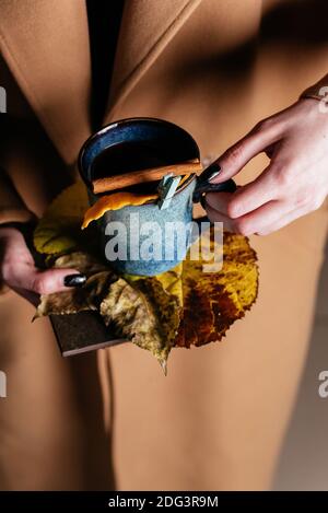 Tassen Glühwein in den Händen eines Mädchens Im Herbstmantel Stockfoto