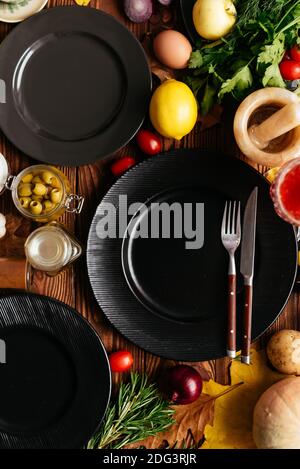 Schwarze Teller auf einem hölzernen Hintergrund mit Gemüse und Obst Ausgelegt Stockfoto