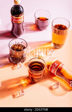 Soda in der Flasche und in Gläsern mit Eis auf Ein heller Hintergrund Stockfoto