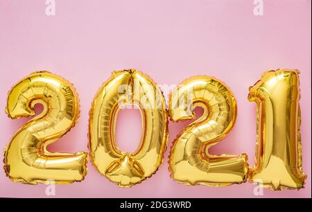 2021 Luftballon Gold Zahlen auf rosa Hintergrund. Weihnachten Happy Silvester Dekor mit Goldfolie Ballons 2021 Copy space Draufsicht Stockfoto