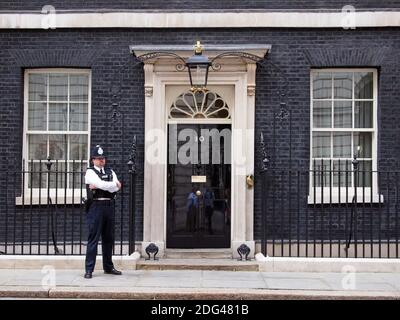 Polizeibeamter, der die Tür der Downing Street 10, London, Großbritannien, bewacht Stockfoto