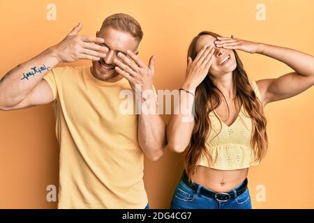 Junges Paar von Freundin und Freund umarmt und zusammen stehend Abdeckung Augen mit Händen lächelnd fröhlich und lustig. Blind Konzept. Stockfoto