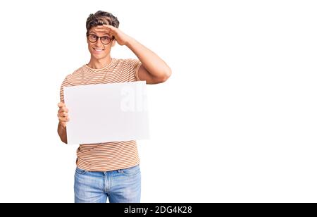 Junger gutaussehender Mann mit leerem leeren Banner gestresst und frustriert mit der Hand auf dem Kopf, überrascht und wütend Gesicht Stockfoto