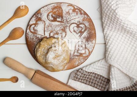 Schritt-für-Schritt-Rezept für herzförmige Kuchen. Schritt 3. Mehl und Salz dazugeben, den Teig kneten. Flach liegend. Stockfoto