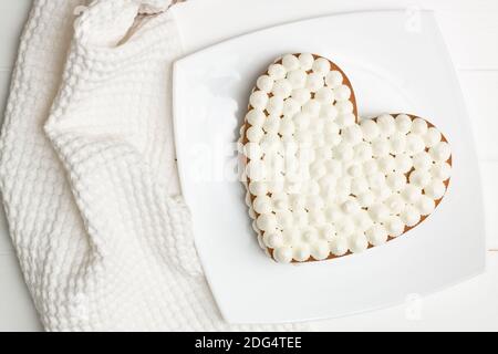 Schritt-für-Schritt-Rezept für herzförmige Kuchen. Schritt 11: Die Kuchen mit Sahne übereinander legen. Flach liegend. Stockfoto