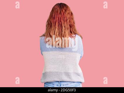 Junge lateinische Frau in legerer Kleidung stehend rückwärts wegschauen Mit gekreuzten Armen Stockfoto