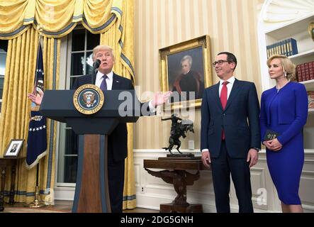 Präsident Donald Trump spricht neben Steven Munchin und seiner Verlobten Louise Linton, bevor Munchin als Finanzminister vereidigt wurde, während einer Zeremonie im Weißen Haus in Washington, D.C., am 13. Februar 2017. Mnuchin wurde heute vom Senat 54-47 bestätigt. Foto von Kevin Dietsch/Pool/ABACAPRESS.COM Stockfoto