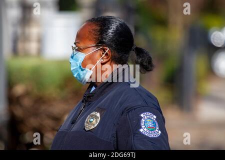 Alexandria, VA, USA 11-28-2020: Ein afroamerikanischer Polizeibeamter, der in der Abteilung für Parkplatzdurchsetzung arbeitet, ist im Freien im Dienst. Sie trägt Gesichtsmaske Stockfoto