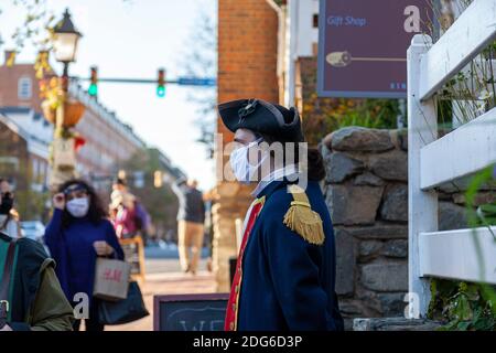 Alexandria, VA, USA 11-28-2020: Ein Mitarbeiter, der im Besucherzentrum des touristischen historischen Alexandria arbeitet, wartet draußen mit einem Minutenkostüm Stockfoto