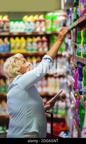 Frau, die Haushaltsreiniger im Laden kauft Stockfoto