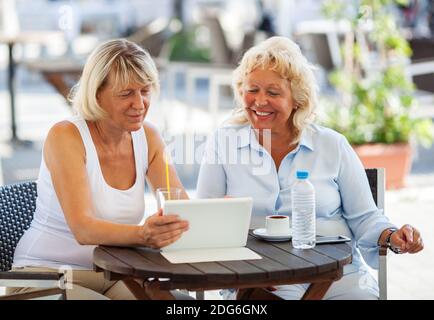 Weibliche Freunde, die etwas auf Tablet-PC im Café Stockfoto