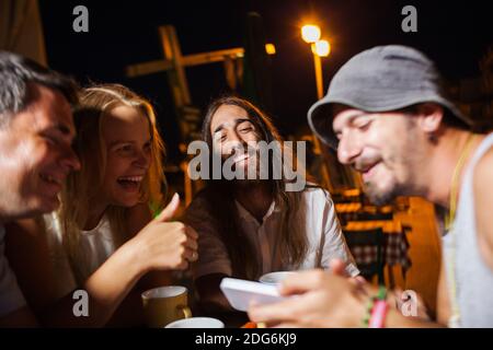 Glückliche Freunde, die Fotos auf dem Handy ansehen Stockfoto