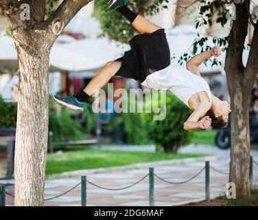 Junger Athlet bei extremer Akrobatik im Freien Stockfoto