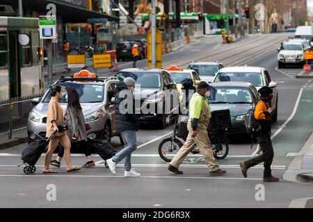 Melbourne, Australien, 12. August 2020. Fußgänger, die Masken tragen und ihre Einkäufe tragen, überqueren eine Kreuzung im CBD. Trotz der schwersten Einschränkungen in der Geschichte des Landes, Melbourne sah ein höheres Maß an Fußverkehr am Mittwoch im Vergleich zu früheren Tagen darauf hindeutet, dass die Öffentlichkeit bereits müde von den Einschränkungen ihrer Freiheiten während COVID-19 in Melbourne, Australien. Victoria hat 21 weitere COVID-bedingte Todesfälle und 410 neue Fälle verzeichnet, was seinen tödlichsten Tag seit Beginn der Pandemie markiert.Quelle: Dave Hewison/Alamy Live News Stockfoto