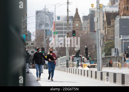 Melbourne, Australien, 18. August 2020. Ein Paar in Gesichtsmasken trotzen dem Regen während der COVID-19 in Melbourne, Australien. Hotelquarantäne in Verbindung mit 99 % der COVID-19-Fälle in Victoria, teilte die Untersuchung mit. Dies kommt inmitten von weiteren 222 neuen Fällen zusammen mit 17 Todesfälle entdeckt. Melbourne fährt fort, unter Stufe 4 Beschränkungen mit Spekulationen zu reel, dass es verlängert wird.Quelle: Dave Hewison/Alamy Live News Stockfoto