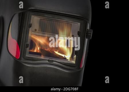 Reflexion der Flamme in die Glas-Schutzmaske, auf schwarzem Hintergrund isoliert Stockfoto