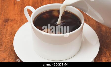 Tasse Kaffee mit Milch Nahaufnahme auf Holzhintergrund Stockfoto