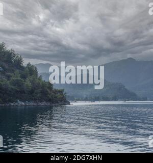 Dramatischer Himmel über dem Meer. Berglandschaft Meer an einem bewölkten Tag. Blick vom Meer. Quadratisches Bild Stockfoto