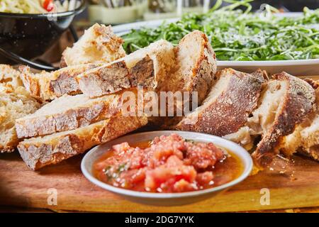 Hausgemachtes italienisches Focaccia-Brot in Scheiben geschnitten auf einem Holzbrett Stockfoto