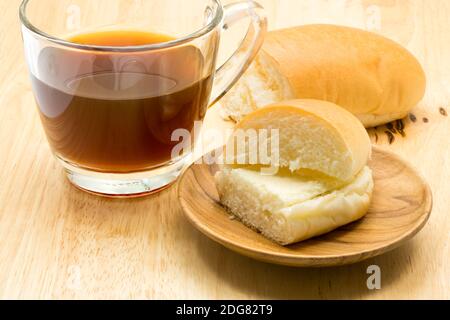 Hotdog-Brot gefüllt mit gesüßter Buttercreme und einer Tasse Kaffee Stockfoto