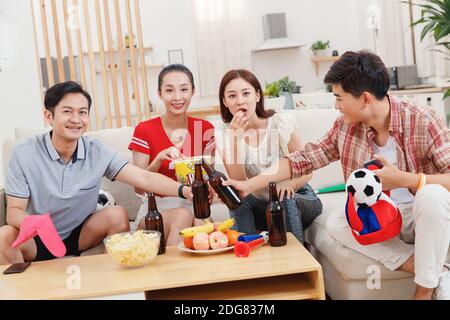 Glückliche junge Freunde, um das Spiel zu Hause zu sehen Stockfoto