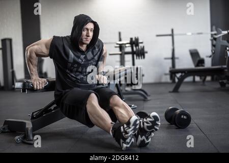 Brutaler Mann im Fitnessstudio Stockfoto