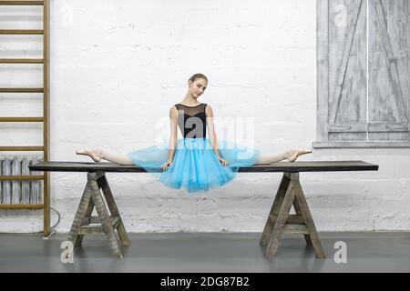 Ballerina sitzt bei Split im studio Stockfoto