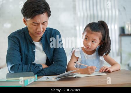 Der junge Mann zu Coaching Tochter bei seinen Hausaufgaben Stockfoto