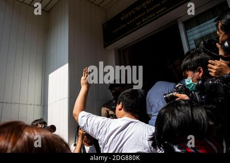 Bangkok, Thailand. Dezember 2020. Parit 'Penguin' Chiwarak hält den dreifingerigen Gruß vor dem Betreten der Polizeistation, um zu hören, dass am Dienstag, den 08. Dezember 2020, die Hauptanklagen gegen ihn und drei andere (Abschnitt 112 des Strafgesetzbuches) in der Nonthaburi Polizeistation in Bangkok, Thailand erhoben werden. Die Protestführer Parit 'Penguin' Chiwarak, Panupong 'mike'' Jadnok, Panusaya 'rung' Sithijirawattanakul und Chinnawat Chankrachang tauchten auf der Polizeiwache auf, um zu hören, wie gegen sie wegen ihrer Reden, die den thailändischen Mon kritisierten, die Hauptanklagen erhoben wurden Stockfoto