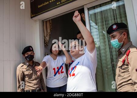 Bangkok, Thailand. Dezember 2020. Parit 'Penguin' Chiwarak (rechts) Panupong 'mike'' Jadnok (hinten), Und Panusaya "läutet" Sithijirawattanakul (links), hält den dreifingerigen Gruß vor dem Betreten der Polizeistation hoch, um zu hören, wie gegen sie die Hauptanklagen erhoben werden (Abschnitt 112 des Strafgesetzbuches), die am Dienstag, den 08. Dezember 2020 in der Nonthaburi Polizeistation in Bangkok, Thailand, erhoben werden. Die Protestführer Parit 'Penguin' Chiwarak, Panupong 'mike'' Jadnok, Panusaya 'rung' Sithijirawattanakul und Chinnawat Chankrachang tauchten auf der Polizeiwache auf, um die Majestät zu hören Stockfoto