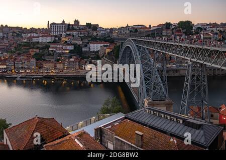 Straßenbahn und Fußgänger überqueren bei Sonnenuntergang die Ponte Luis in Porto. Aufgenommen an einem späten Frühlingsabend Stockfoto