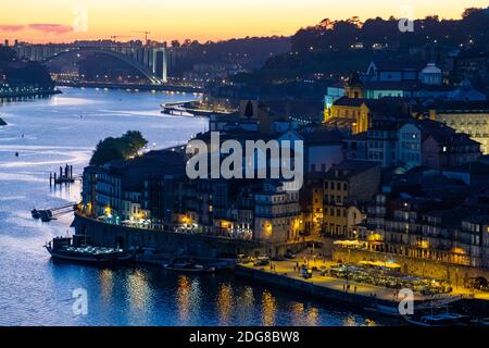 Erhöhte breite Aufnahme von Bairro da Ribeira in Porto während einer schönen Dämmerung. Die Ponte Arrabida ist im Hintergrund Stockfoto
