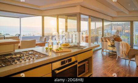 Sonnige Luxus-Haus Vitrine Innenküche mit Sonnenuntergang Meerblick Stockfoto