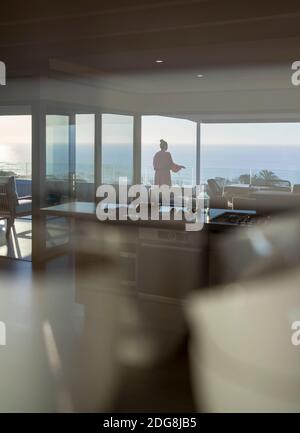 Frau auf einem luxuriösen Balkon mit Panoramablick auf das Meer Stockfoto