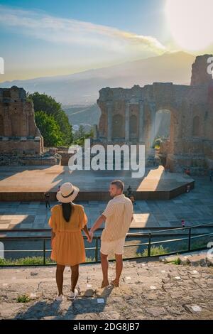 Taormina Sizilien, Paar beobachten Sonnenuntergang auf den Ruinen des antiken griechischen Theaters in Taormina, Sizilien. Paar mittleren Alters im Urlaub Sicilia Stockfoto