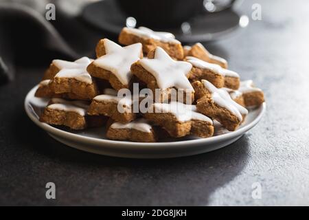 Eiswürfchen Lebkuchensterne. Traditionelle Weihnachtskekse auf schwarzem Tisch. Stockfoto