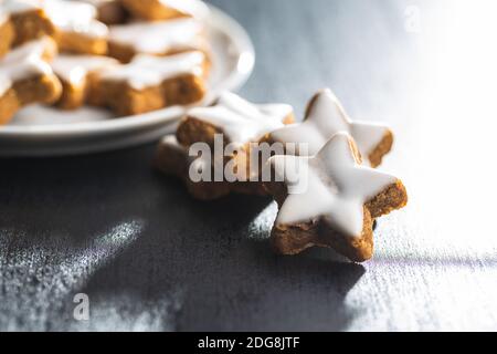 Eiswürfchen Lebkuchensterne. Traditionelle Weihnachtskekse auf schwarzem Tisch. Stockfoto