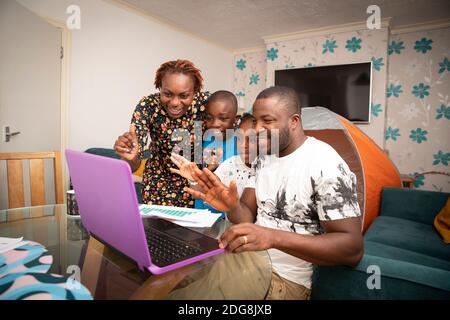 Glückliche Familie Video chatten am Laptop auf Esstisch Stockfoto