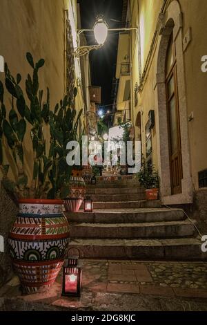 Taormina Sizilien Oktober 2020, alte Straßen von Taormina während des Abends mit den Lichtern an und Menschen auf der Terrasse. Stockfoto