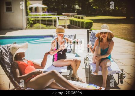 Ältere Freundinnen trinken Champagner und sonnen sich auf der sonnigen Terrasse Stockfoto