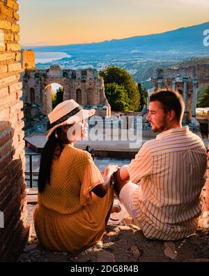 Taormina Sizilien, Paar beobachten Sonnenuntergang auf den Ruinen des antiken griechischen Theaters in Taormina, Sizilien. Paar mittleren Alters im Urlaub Sicilia Stockfoto