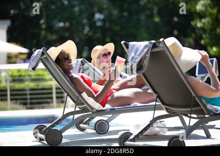 Glückliche ältere Frauen Freunde Sonnenbaden am sonnigen Sommer am Pool Stockfoto