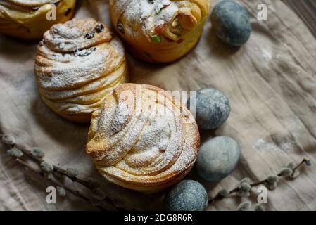 Traditionelle Cupcake Osterkuchen Kraffin mit Rosinen auf dunklem Holz Hintergrund. Hausgemachte Kuchen Cruffin mit kandierten Früchten. Natürlich Eier mit bemalt Stockfoto