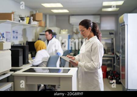 Wissenschaftlerin mit digitalem Tablet im Labor Stockfoto