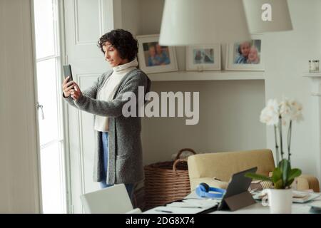Frau Video chatten mit Smartphone zu Hause Stockfoto