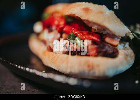 Ein selektiver Fokus Schuss von frischen leckeren Chickenburger auf einem Dunkler Hintergrund Stockfoto